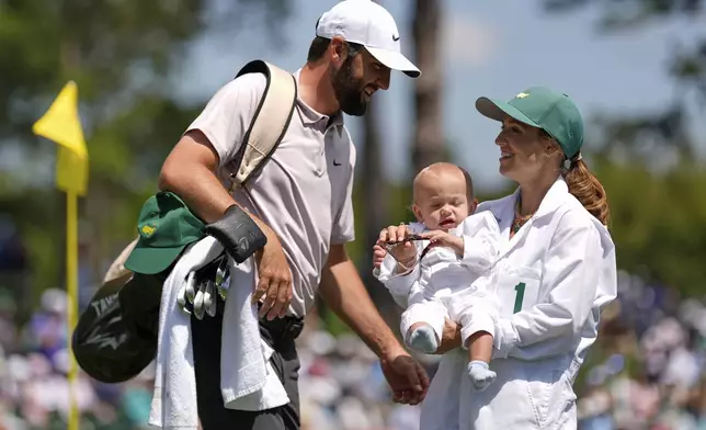 Scottie Scheffler interacts with his wife, Meredith, and their son, Bennett, on the seventh hole during the par-3 contest at the Masters golf tournament, Wednesday, April 9, 2025, in Augusta, Ga. (AP Photo/Julia Demaree Nikhinson)
