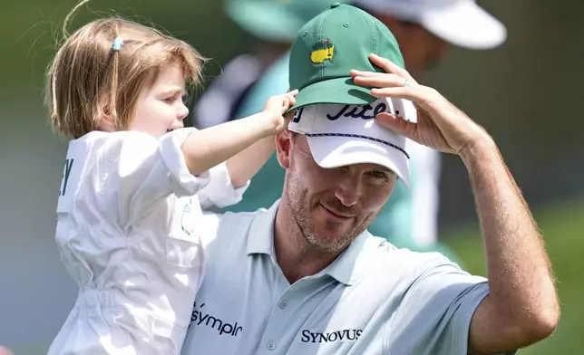 Russell Henley and daughter, Jane, 2, interact on the first hole during the par-3 contest at the Masters golf tournament, Wednesday, April 9, 2025, in Augusta, Ga. (AP Photo/Ashley Landis)