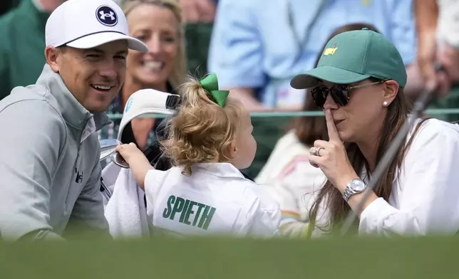 Jordan Spieth and wife Annie Verret interact with daughter Sophie as they wait to play on the first hole during a practice around at the Masters golf tournament, Wednesday, April 9, 2025, in Augusta, Ga. (AP Photo/George Walker IV)