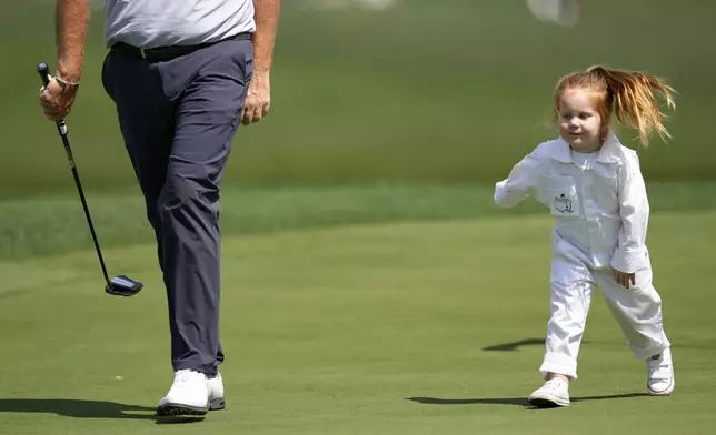 Shane Lowry, of Ireland, walks on the first hole with daugher Ivy, 3, during the par-3 contest at the Masters golf tournament, Wednesday, April 9, 2025, in Augusta, Ga. (AP Photo/Ashley Landis)