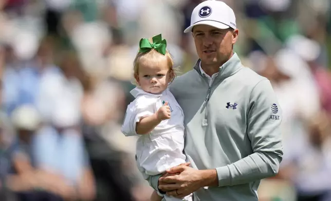 Jordan Spieth holds his daughter Sophie on the seventh hole during the par-3 contest at the Masters golf tournament, Wednesday, April 9, 2025, in Augusta, Ga. (AP Photo/Julia Demaree Nikhinson)