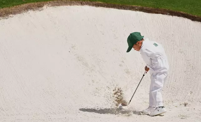 Byeong Hun An's, of South Korea, son Sun-woo, 5, hits out of the bunker on the first hole during the par-3 contest at the Masters golf tournament, Wednesday, April 9, 2025, in Augusta, Ga. (AP Photo/Ashley Landis)