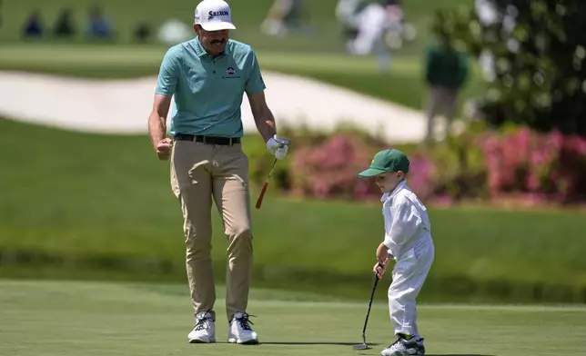 Keegan Bradley celebrates after his son Cooper, 4, made a putt on the fourth hole during the par-3 contest at the Masters golf tournament, Wednesday, April 9, 2025, in Augusta, Ga. (AP Photo/George Walker IV)