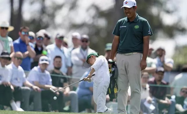 Byeong Hun An, of South Korea, watches his son Sun-woo, 5, hit on the first hole during the par-3 contest at the Masters golf tournament, Wednesday, April 9, 2025, in Augusta, Ga. (AP Photo/Ashley Landis)