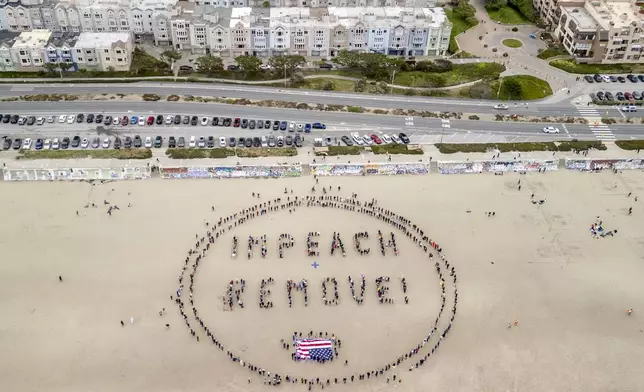 Protesters form a "Impeach &amp; Remove" human banner on Ocean Beach during a protest against U.S. President Donald Trump, in San Francisco, Saturday, April 19, 2025. (Stephen Lam/San Francisco Chronicle via AP)