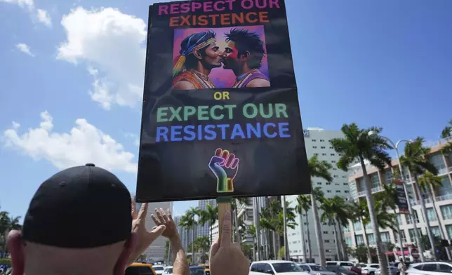A person holds a sign in support of gay rights during a protest against the Trump administration, Saturday, April 19, 2025, in Miami. (AP Photo/Lynne Sladky)