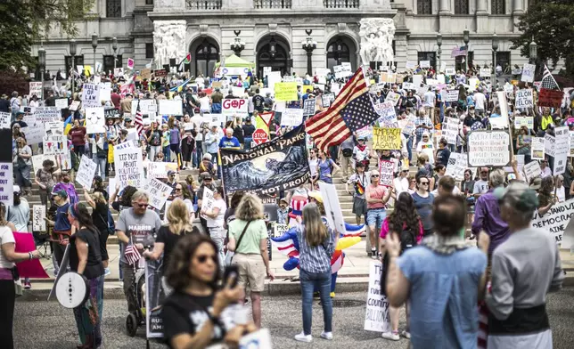 Protesters rally at the state capitol in Harrisburg, Pa., during the Day of Action protest against the Trump Administration. Saturday, April 19, 2025. (Zach Gleiter/The Patriot-News via AP)