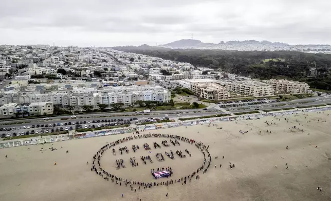 Protesters form a "Impeach &amp; Remove" human banner on Ocean Beach during a protest against U.S. President Donald Trump, in San Francisco, Saturday, April 19, 2025. (Stephen Lam/San Francisco Chronicle via AP)