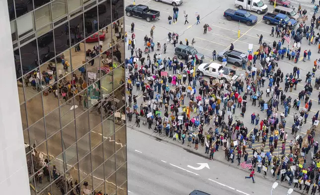 People gather outside the offices of Sen. Lisa Murkowski and Dan Sullivan during a protest against President Trump and his policies on Saturday, April 19, 2025 in Anchorage, Alaska. (Loren Holmes/Anchorage Daily News via AP)