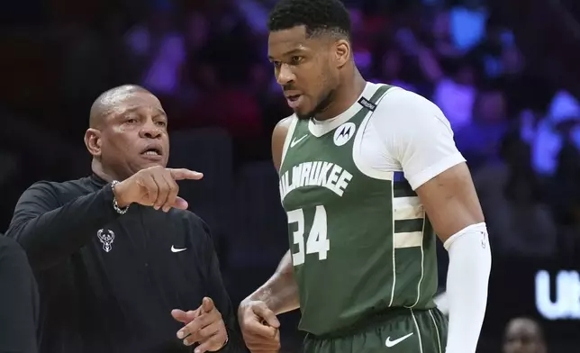 Milwaukee Bucks head coach Doc Rivers, left, talk with forward Giannis Antetokounmpo (34) during the second half of an NBA basketball game against the Miami Heat, Saturday, April 5, 2025, in Miami. (AP Photo/Lynne Sladky)