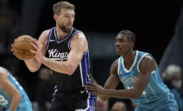 Charlotte Hornets forward Moussa Diabate, right, guards against Sacramento Kings forward Domantas Sabonis, left, during the first half of an NBA basketball game Friday, April 4, 2025, in Charlotte, N.C. (AP Photo/Jacob Kupferman)
