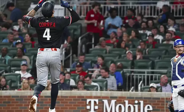 Minnesota Twins shortstop Carlos Correa (4) celebrates his solo homerun against the Atlanta Braves during the fourth inning in a baseball game at Truist Park, Saturday, April 19, 2025, in Atlanta. (AP Photo/ John David Mercer)