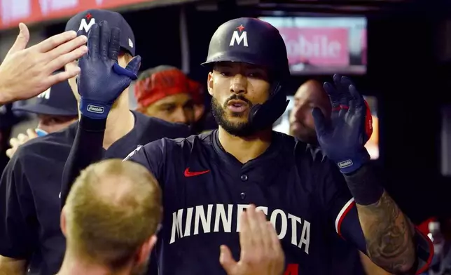 Minnesota Twins shortstop Carlos Correa (4) celebrates his solo homerun in the dugout against the Atlanta Braves during the fourth inning in a baseball game at Truist Park, Saturday, April 19, 2025, in Atlanta. (AP Photo/ John David Mercer)
