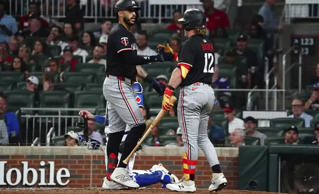 Minnesota Twins shortstop Carlos Correa (4) celebrates his solo homerun at the plate with Minnesota Twins outfielder Harrison Bader (12) against the Atlanta Braves during the fourth inning in a baseball game at Truist Park, Saturday, April 19, 2025, in Atlanta. (AP Photo/ John David Mercer)