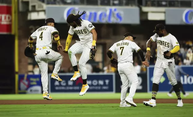 From left, San Diego Padres' Luis Arraez, Fernando Tatis Jr., Jose Iglesias and Jason Heyward celebrate after the team defeated the Colorado Rockies in a baseball game Saturday, April 12, 2025, in San Diego. (AP Photo/Derrick Tuskan)