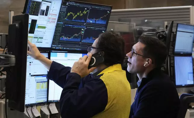 A pair of options traders work on the floor of the New York Stock Exchange, Friday, April 11, 2025. (AP Photo/Richard Drew)