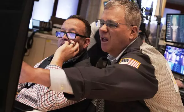 Traders Bryan Masseria, left and Columb Lytle work on the floor of the New York Stock Exchange, Thursday, April 10, 2025. (AP Photo/Richard Drew)