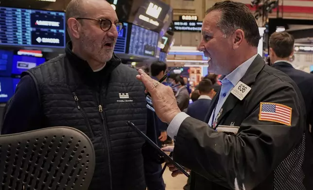 Specialist Peter Giacchi, left, and trader Edward Curran work on the floor of the New York Stock Exchange, Friday, April 11, 2025. (AP Photo/Richard Drew)