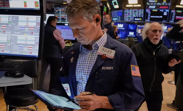 Trader Robert Charmak, left, works on the floor of the New York Stock Exchange, Friday, April 11, 2025. (AP Photo/Richard Drew)