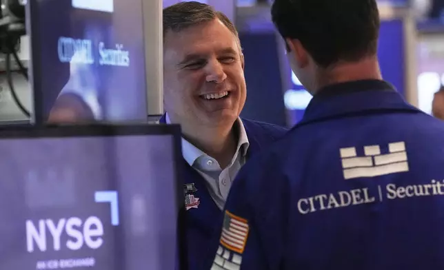 Specialist Thomas Schreck, left, talks with a colleague on the floor of the New York Stock Exchange, Friday, April 11, 2025. (AP Photo/Richard Drew)