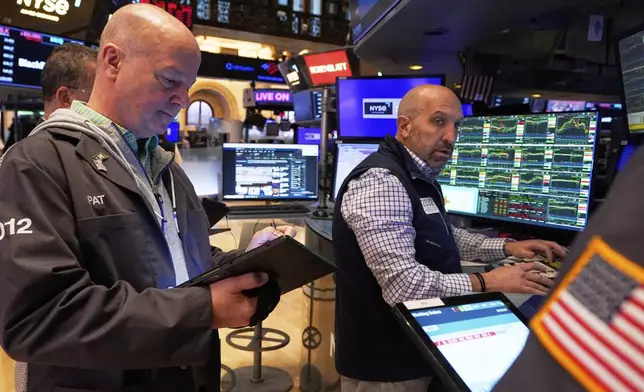 Trader Patrick Casey, left, and specialist Jamie Denaro work on the floor of the New York Stock Exchange, Friday, April 11, 2025. (AP Photo/Richard Drew)