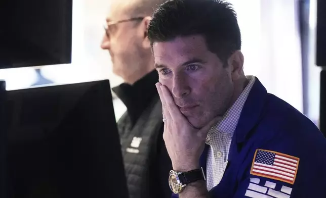 Specialist Thomas McArdle, right, works at his post on the floor of the New York Stock Exchange, Friday, April 11, 2025. (AP Photo/Richard Drew)