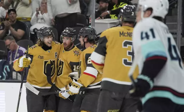 Vegas Golden Knights center William Karlsson, left, celebrates after scoring against the Seattle Kraken during the second period of an NHL hockey game Thursday, April 10, 2025, in Las Vegas. (AP Photo/John Locher)