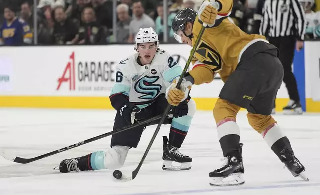 Seattle Kraken center Ryan Winterton (26) sttempts to sopt a pass by Vegas Golden Knights defenseman Kaedan Korczak (6) during the first period of an NHL hockey game Thursday, April 10, 2025, in Las Vegas. (AP Photo/John Locher)