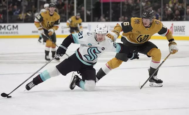 Seattle Kraken center Michael Eyssimont (21) attempts to skate around Vegas Golden Knights defenseman Kaedan Korczak (6) during the first period of an NHL hockey game Thursday, April 10, 2025, in Las Vegas. (AP Photo/John Locher)