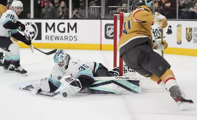 Seattle Kraken goaltender Joey Daccord (35) stops a shot by Vegas Golden Knights center Brett Howden (21) during the second period of an NHL hockey game Thursday, April 10, 2025, in Las Vegas. (AP Photo/John Locher)