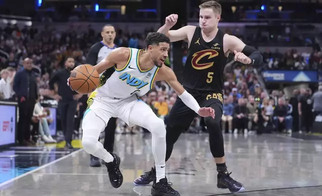 Indiana Pacers guard Tyrese Haliburton (0) drives on Cleveland Cavaliers guard Sam Merrill (5) during the second half of an NBA basketball game in Indianapolis, Thursday, April 10, 2025. (AP Photo/Michael Conroy)