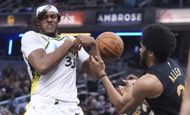Indiana Pacers center Myles Turner (33) and Cleveland Cavaliers center Jarrett Allen (31) fight for a rebound during the first half of an NBA basketball game in Indianapolis, Thursday, April 10, 2025. (AP Photo/Michael Conroy)