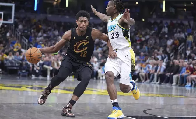 Cleveland Cavaliers forward De'Andre Hunter (12) drives on Indiana Pacers forward Aaron Nesmith (23) during the first half of an NBA basketball game in Indianapolis, Thursday, April 10, 2025. (AP Photo/Michael Conroy)