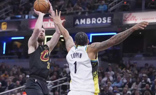 Cleveland Cavaliers forward Dean Wade (32) shoots over Indiana Pacers forward Obi Toppin (1) during the first half of an NBA basketball game in Indianapolis, Thursday, April 10, 2025. (AP Photo/Michael Conroy)