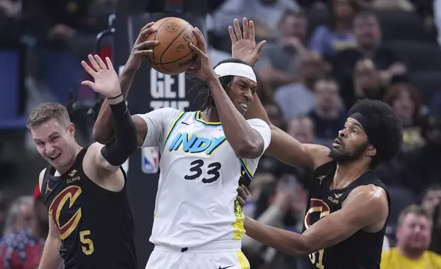 Indiana Pacers center Myles Turner (33) grabs a rebound between Cleveland Cavaliers guard Sam Merrill (5) and center Jarrett Allen (31) during the first half of an NBA basketball game in Indianapolis, Thursday, April 10, 2025. (AP Photo/Michael Conroy)