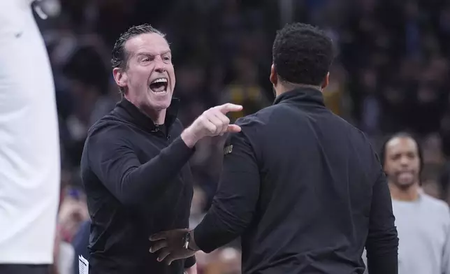 Cleveland Cavaliers head coach Kenny Atkinson, left, is held by associate head coach Johnnie Bryant after receiving his second technical and being ejected during the second half of an NBA basketball game against the Indiana Pacers in Indianapolis, Thursday, April 10, 2025. (AP Photo/Michael Conroy)