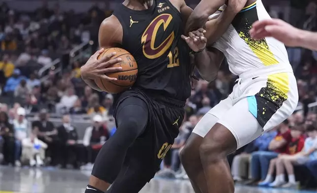Cleveland Cavaliers forward De'Andre Hunter (12) drives on Indiana Pacers forward Jarace Walker (5) during the first half of an NBA basketball game in Indianapolis, Thursday, April 10, 2025. (AP Photo/Michael Conroy)