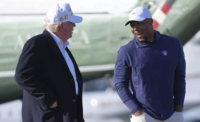 President Donald Trump, left, walks with Philadelphia Eagles football player Saquon Barkley before boarding Air Force One at Morristown Municipal Airport, Sunday, April 27, 2025, in Morristown, N.J. (AP Photo/Evan Vucci)