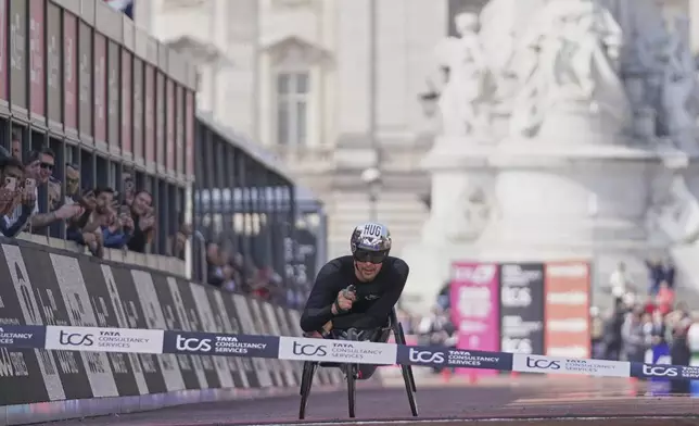 Marcel Hug of Switzerland crosses the line to win the men's wheelchair marathon at the London Marathon, Sunday, April 27, 2025. (AP Photo/Alberto Pezzali)