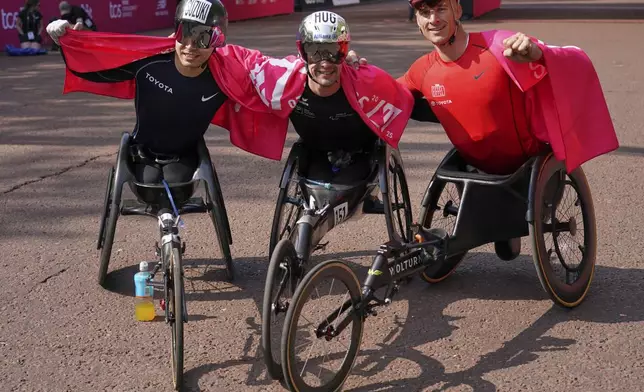 Marcel Hug, centre, of Switzerland winner of the Men's wheelchair race, with second placed Tomoki Suzuki of Japan, left and Jetze Plat of the Netherland, third, pose for photographs at the London Marathon, Sunday, April 27, 2025. (AP Photo/Alberto Pezzali)