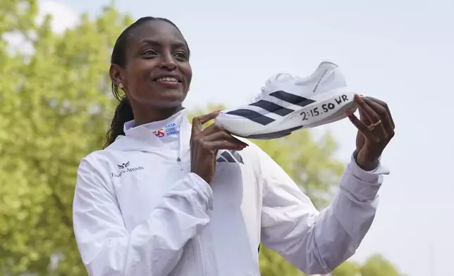 Tigst Assefa of Ethiopia poses for the cameras after setting a new women's only world record time and winning the women's race at the London Marathon, Sunday, April 27, 2025. (AP Photo/Alberto Pezzali)