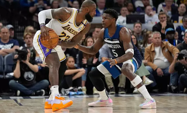 Los Angeles Lakers forward LeBron James (23) handles the ball as Minnesota Timberwolves guard Anthony Edwards (5) defends during the first half of Game 4 of an NBA basketball first-round playoff series, Sunday, April 27, 2025, in Minneapolis. (AP Photo/Abbie Parr)