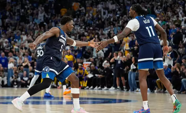 Minnesota Timberwolves center Naz Reid (11) celebrates with guard Anthony Edwards (5) after making a 3-point shot during the second half of Game 4 of an NBA basketball first-round playoff series against the Los Angeles Lakers, Sunday, April 27, 2025, in Minneapolis. (AP Photo/Abbie Parr)