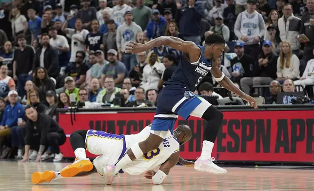 Minnesota Timberwolves guard Anthony Edwards (5) and Los Angeles Lakers forward LeBron Jame, bottom, try to grab possession of the ball during the first half of Game 4 of an NBA basketball first-round playoff series, Sunday, April 27, 2025, in Minneapolis. (AP Photo/Abbie Parr)