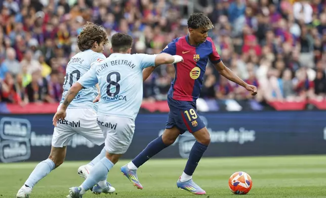 Barcelona's Lamine Yamal, right, challenges for the ball with Celta's Marcos Alonso, left, and Celta's Fran Beltran during a Spanish La Liga soccer match between Barcelona and Celta de Vigo at the Lluis Companys Olympic stadium in Barcelona, Spain, Saturday, April 19, 2025. (AP Photo/Joan Monfort)