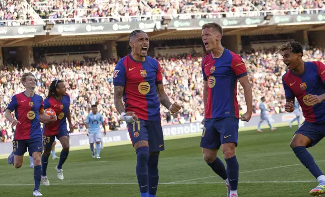 Barcelona's Raphinha, centre, celebrates with teammates after scoring his side's fourth goal during a Spanish La Liga soccer match between Barcelona and Celta de Vigo at the Lluis Companys Olympic stadium in Barcelona, Spain, Saturday, April 19, 2025. (AP Photo/Joan Monfort)