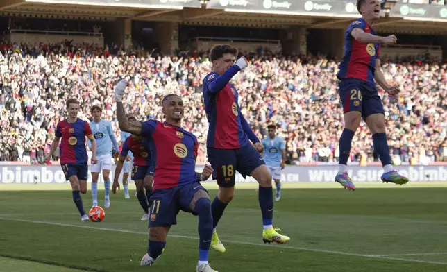 Barcelona's Raphinha, centre left, celebrates with teammates after scoring his side's fourth goal during a Spanish La Liga soccer match between Barcelona and Celta de Vigo at the Lluis Companys Olympic stadium in Barcelona, Spain, Saturday, April 19, 2025. (AP Photo/Joan Monfort)