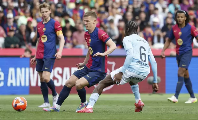 Barcelona's Dani Olmo, centre, challenges for the ball with Celta's Ilaix Moriba during a Spanish La Liga soccer match between Barcelona and Celta de Vigo at the Lluis Companys Olympic stadium in Barcelona, Spain, Saturday, April 19, 2025. (AP Photo/Joan Monfort)