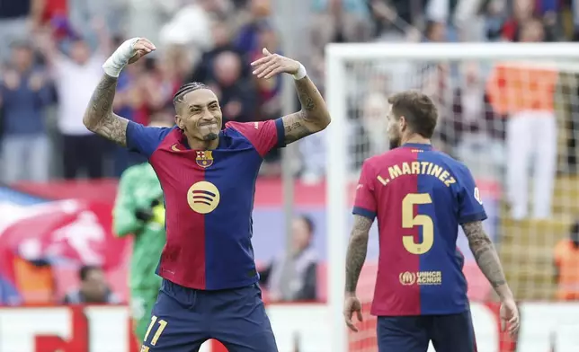 Barcelona's Raphinha, left, celebrates after scoring his side's third goal during a Spanish La Liga soccer match between Barcelona and Celta de Vigo at the Lluis Companys Olympic stadium in Barcelona, Spain, Saturday, April 19, 2025. (AP Photo/Joan Monfort)