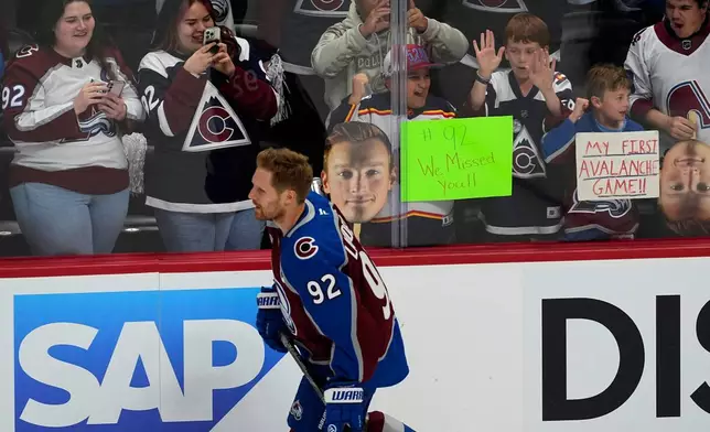Fans cheer as Colorado Avalanche left wing Gabriel Landeskog warms up before the first period of Game 3 of an NHL first-round hockey playoff series against Dallas Wednesday, April 23, 2025, in Denver. (AP Photo/David Zalubowski)